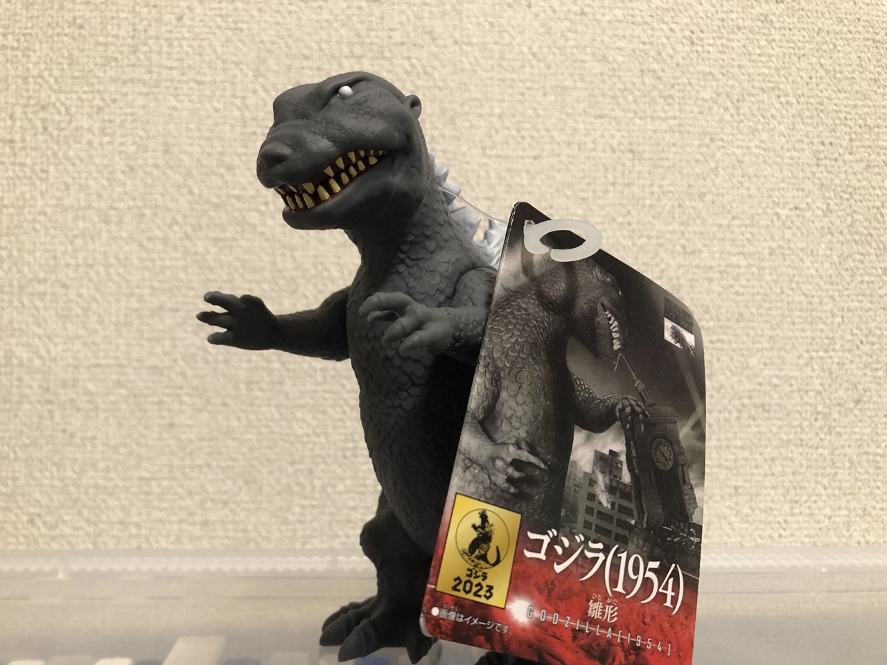 ゴジラ雛形のソフビ。少し頭が大きくトカゲっぽい顔をしている。皮膚はうろこ状。目は白目