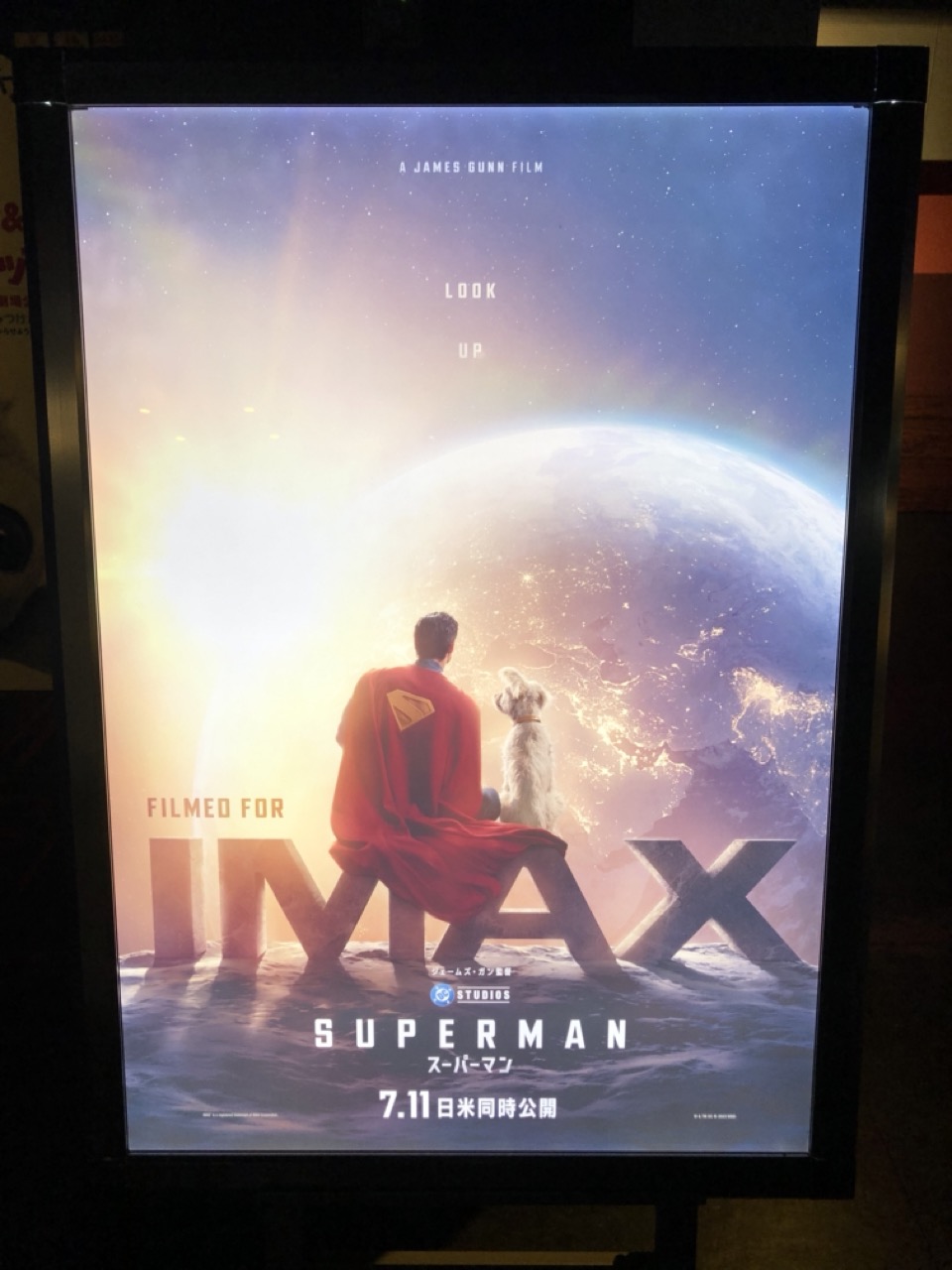 スーパーマンのIMAXポスター。月でIMAXロゴに座ったスーパーマンとクリプトが地球を眺めている